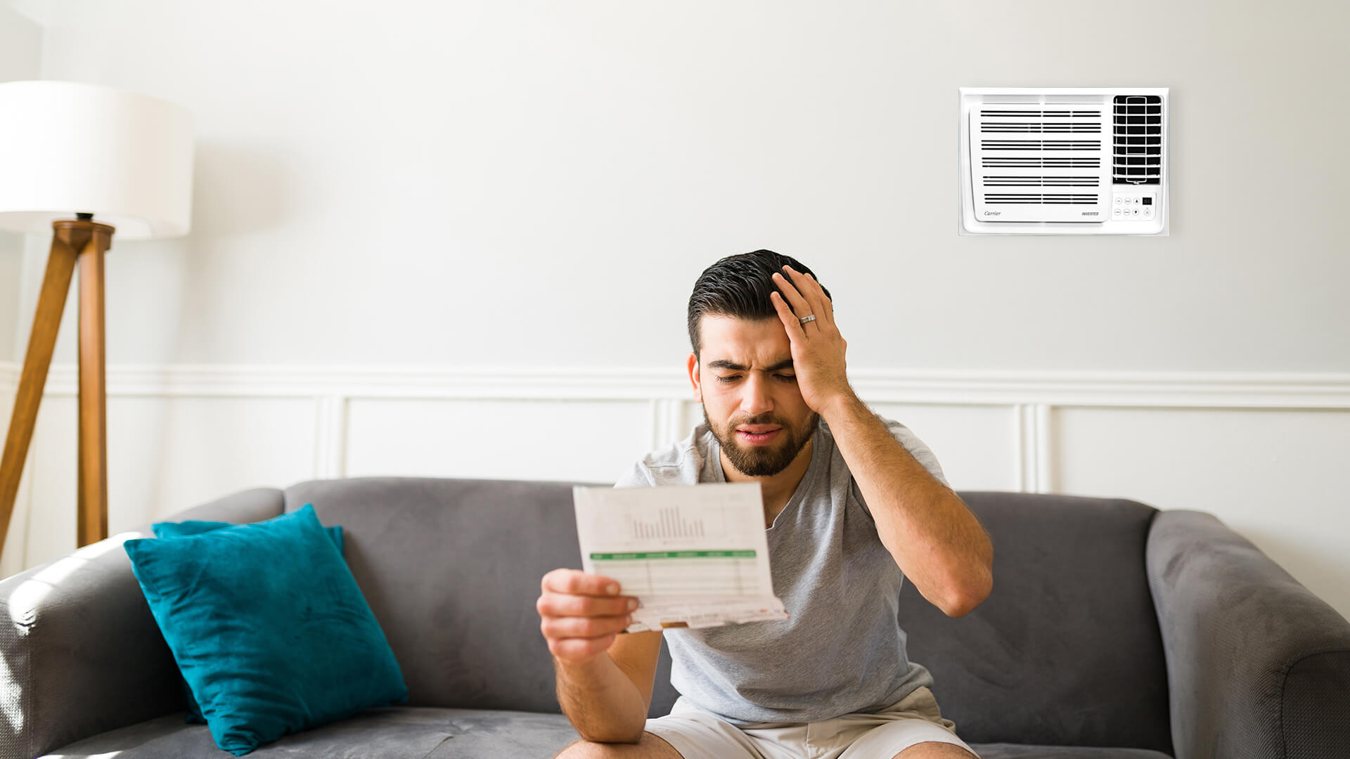 man-looking-at-his-electric-bill-carrier-wrac-window-room-aircon-unit-at-the-back